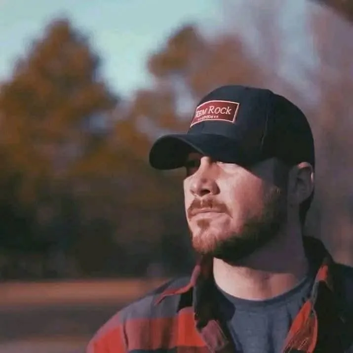 Man in a "Rem Rock" hat and flannel shirt. Could be a Florida painting services contractor.