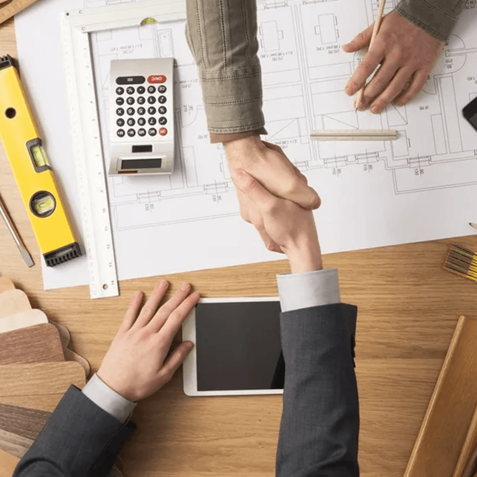 Handshake over blueprints and a tablet, possibly discussing commercial painting in Orlando.