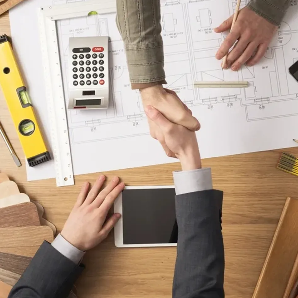 Handshake over blueprints and a tablet, possibly discussing commercial painting in Orlando.