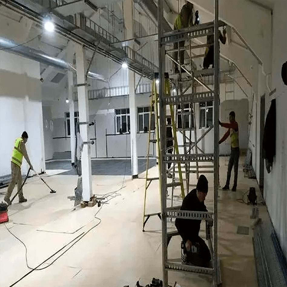 Commercial painting in Orlando: Workers on scaffolding and ladder in a large space.