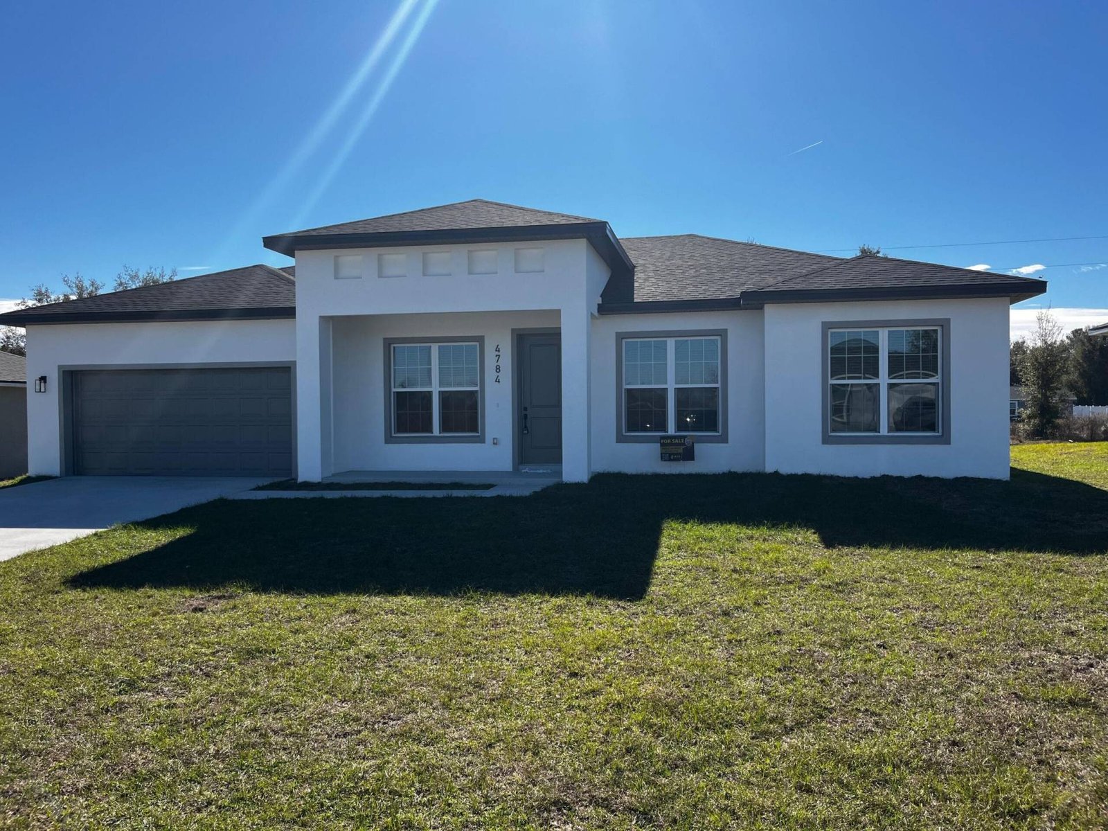 New single-story home with a gray roof and white exterior paint on a sunny day. Address: 4784.