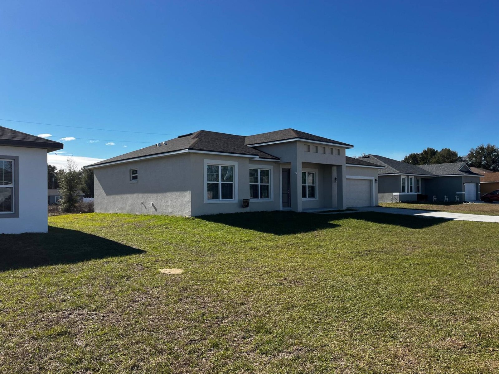New single-family home with green lawn under a clear blue sky.